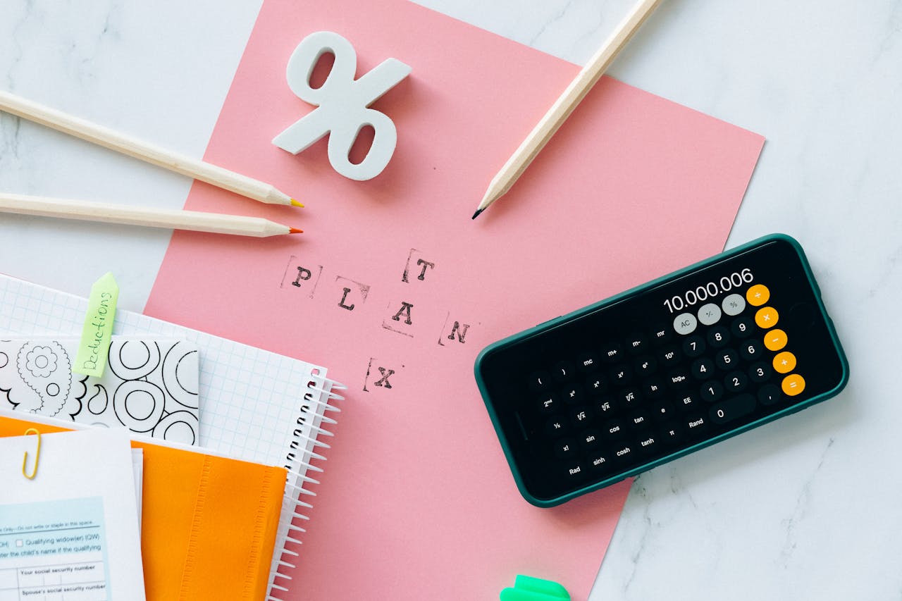 Flat lay showing tax planning tools including a calculator, pencils, and stationery items.